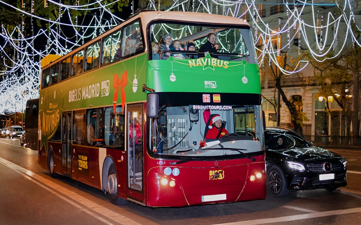 Double-decker bus on Madrid Navibus Christmas Tour with festive lights.