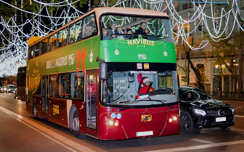Double-decker bus on Madrid Navibus Christmas Tour with festive lights.