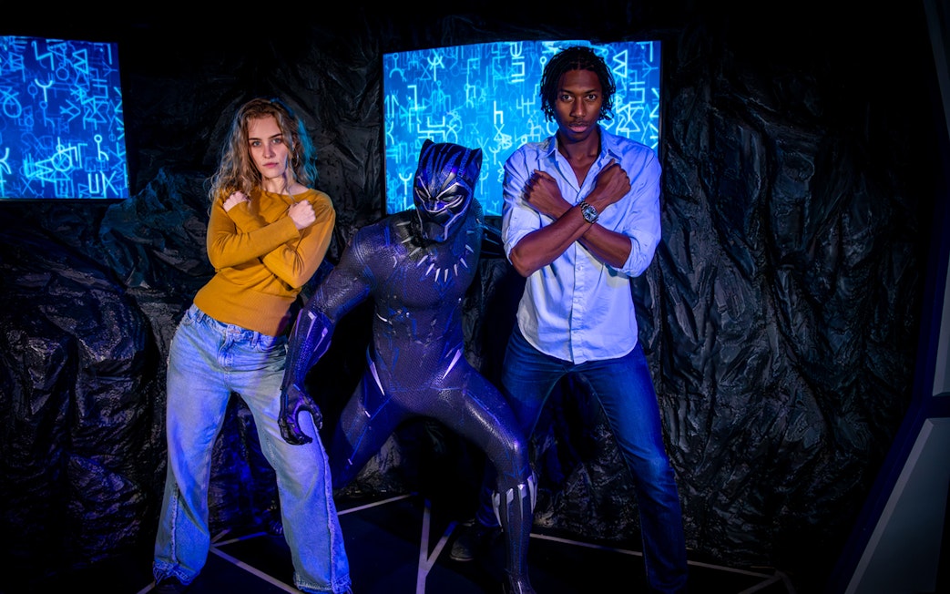 Black Panther figure with visitors posing at Madame Tussauds London.