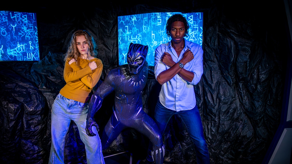 Black Panther figure with visitors posing at Madame Tussauds London.