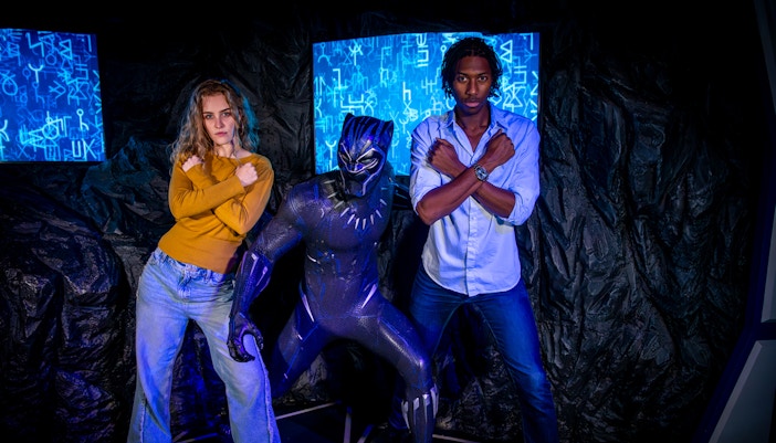 Black Panther figure with visitors posing at Madame Tussauds London.