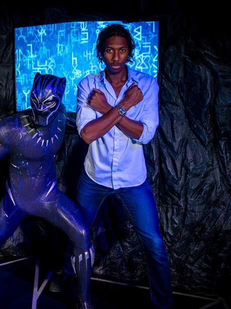 Black Panther figure with visitors posing at Madame Tussauds London.