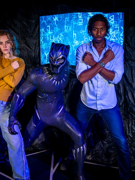 Black Panther figure with visitors posing at Madame Tussauds London.