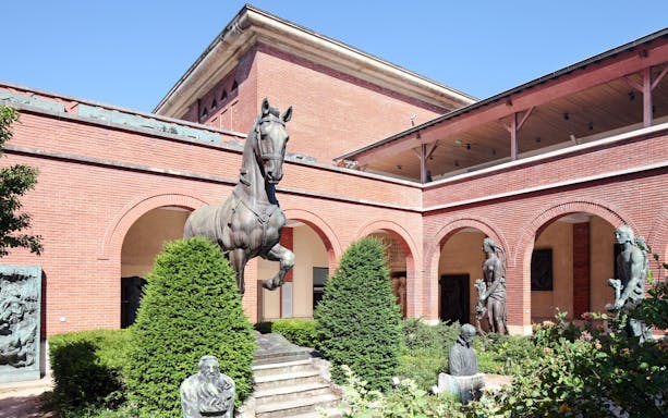 Bourdelle Museum exterior with bronze horse statue and sculptures in Paris courtyard.