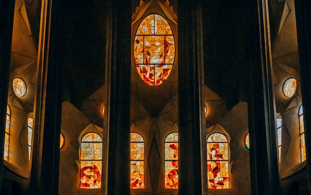 Stained glass windows inside Sagrada Familia, Barcelona, showcasing vibrant colors and intricate designs.