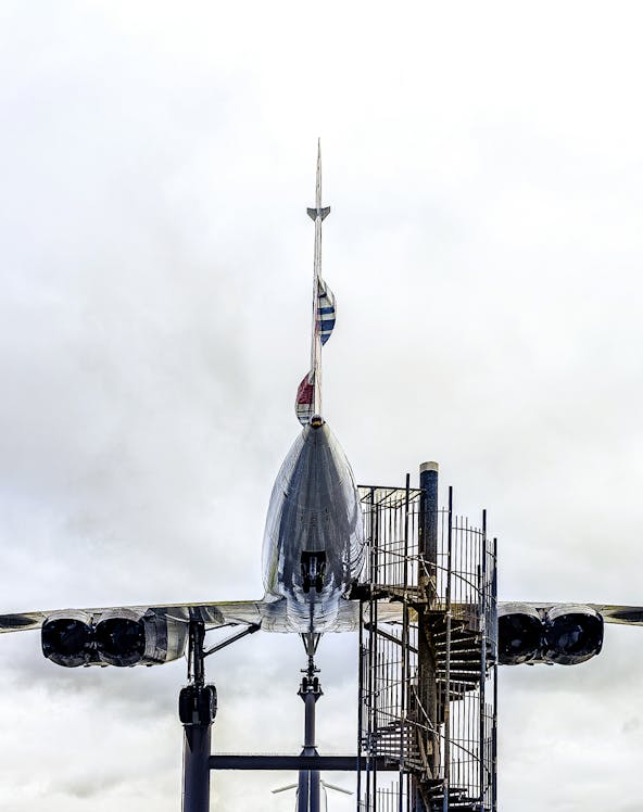 Concorde aircraft displayed at an aviation museum with spiral staircase access.