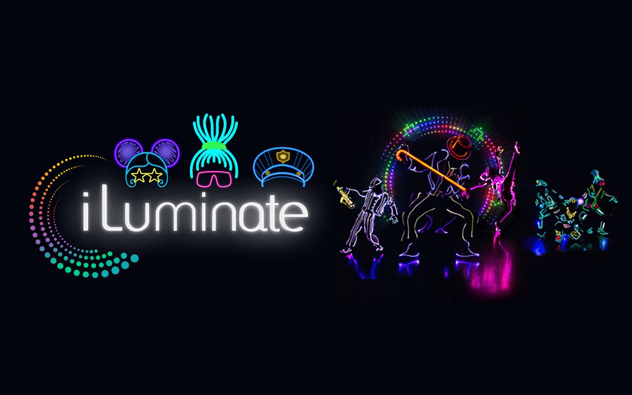 iLuminate dancers performing in neon lights against a dark background.