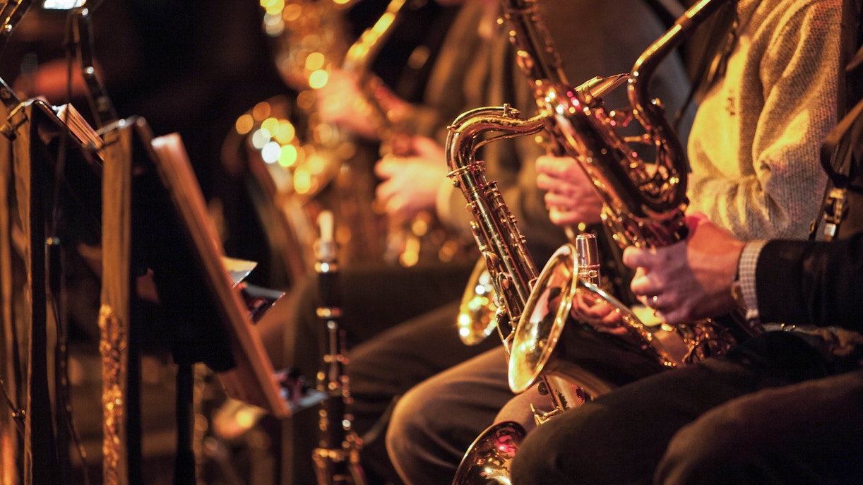 Musicians playing saxophones in a jazz band performance.
