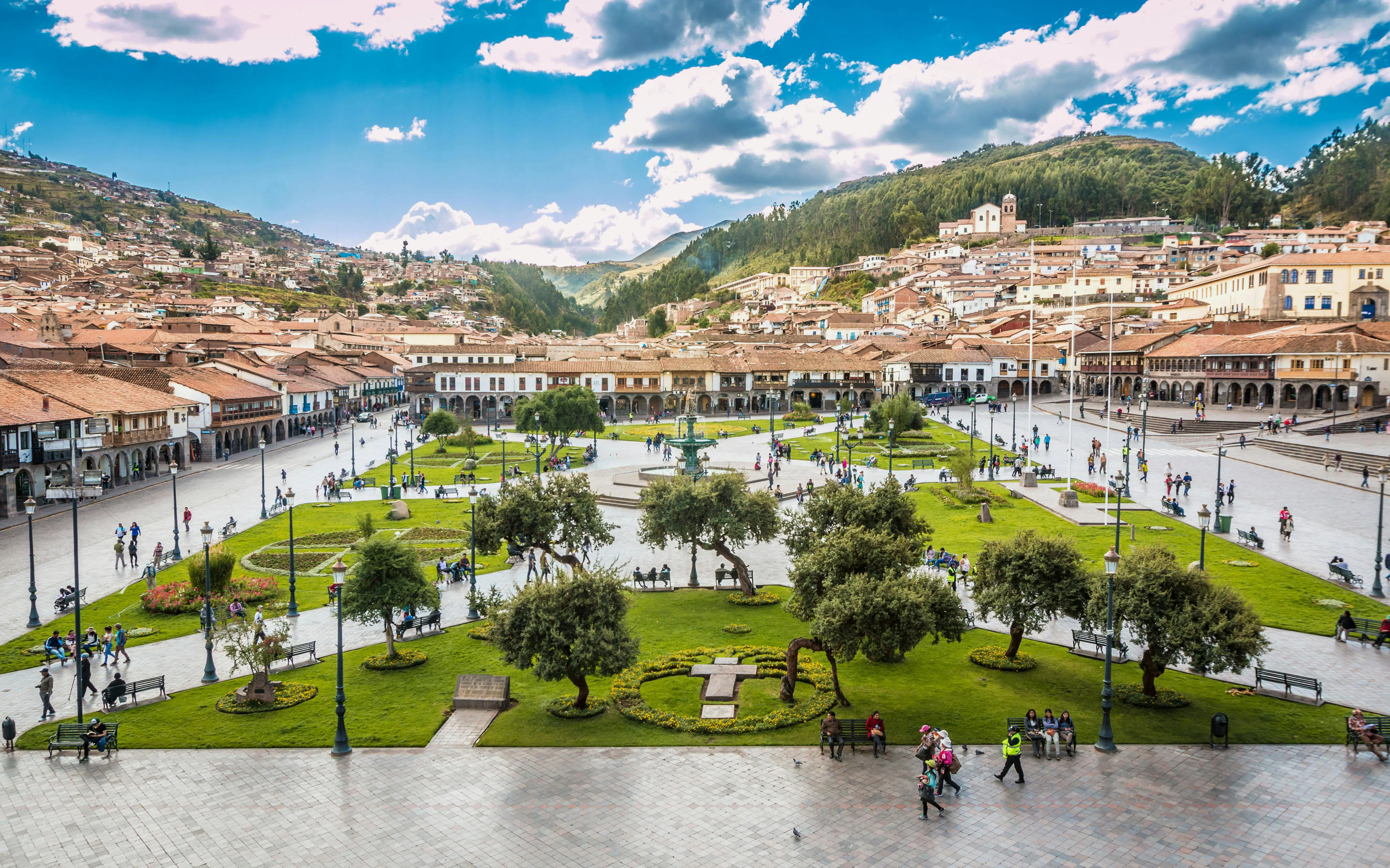 Plaza de Armas in Cusco, Peru with people walking and historic buildings in the background.