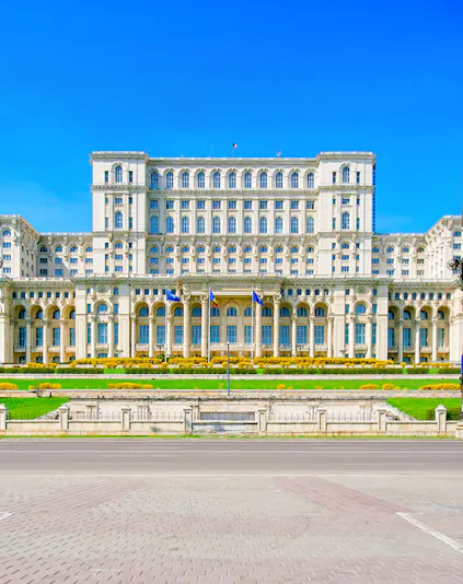 Palace of the Parliament in Bucharest, Romania, with clear blue sky.