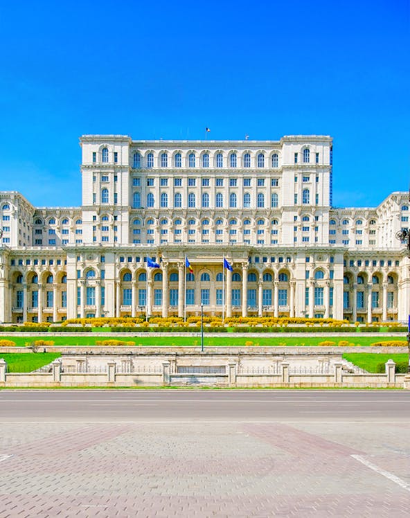 Palace of the Parliament in Bucharest, Romania, with clear blue sky.