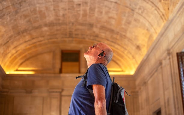 Man with audio guide admiring the Roman Pantheon interior.