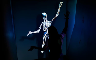 Person interacting with a digital skeleton display at DeJa Vu Museum Berlin.