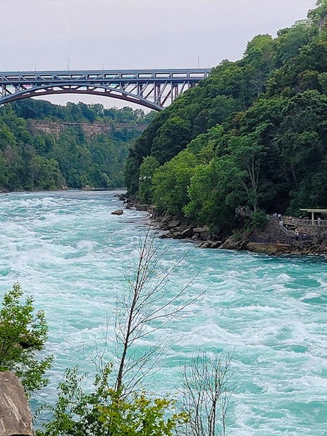 Niagara River flowing through Whirlpool State Park with a bridge in the background, USA.
