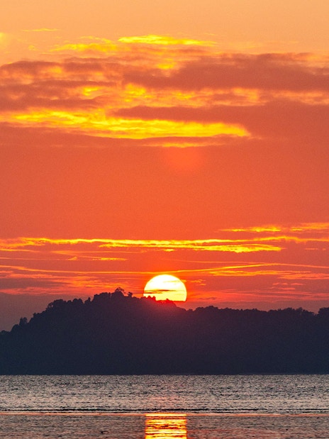 Sunrise over an island in the Andaman Sea during a tour from Phuket.