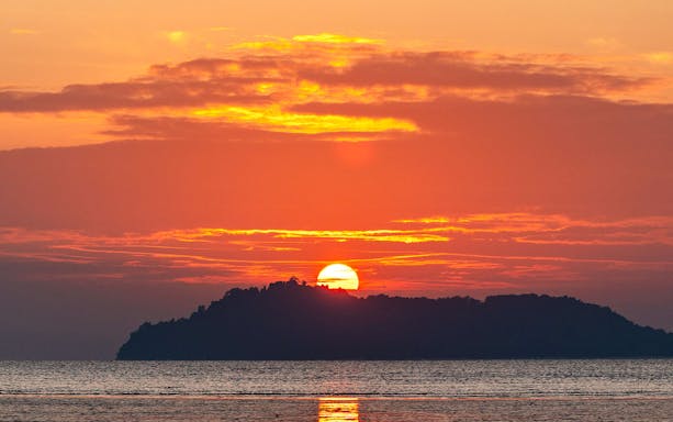 Sunrise over an island in the Andaman Sea during a tour from Phuket.