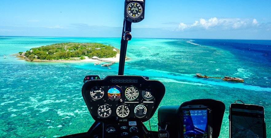 Helicopter cockpit view of Heron Island and Great Barrier Reef waters.