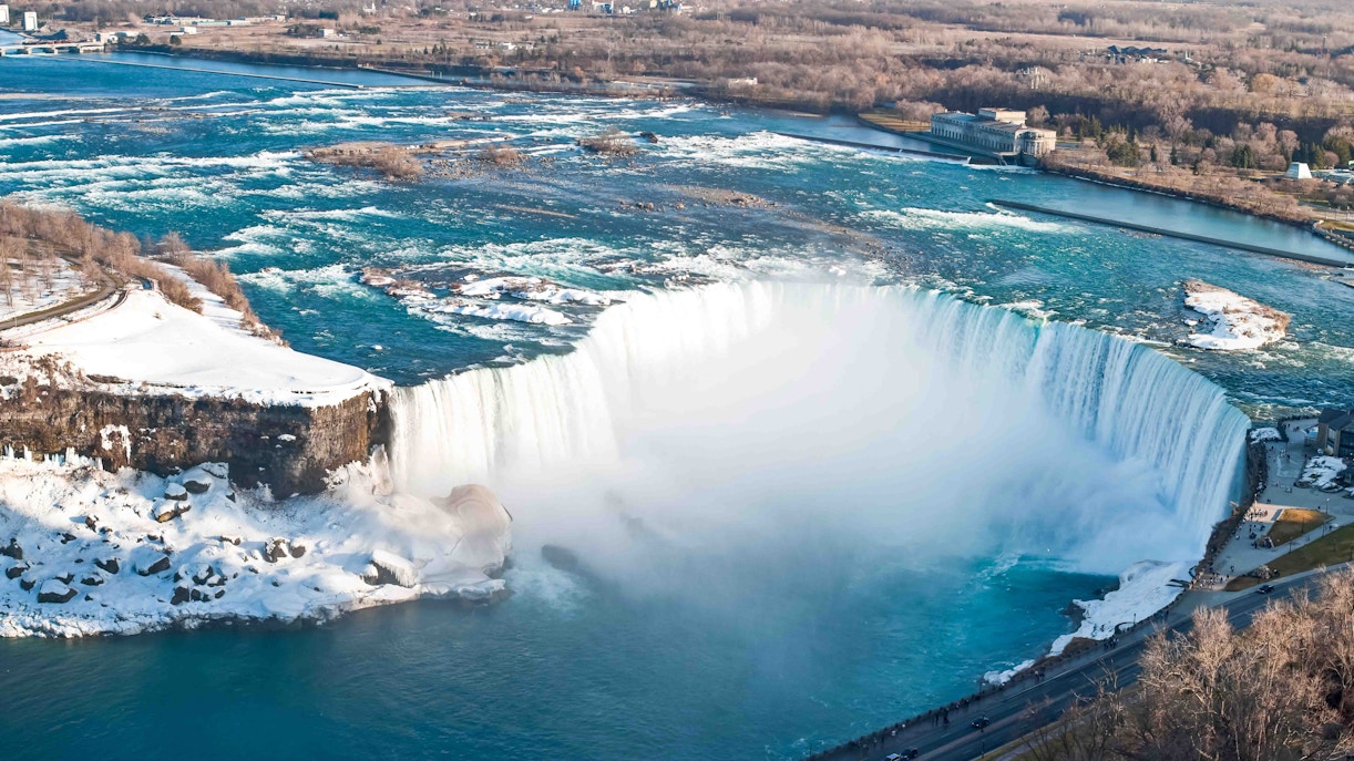 Niagara Falls winter view with snow-covered landscape and flowing waterfalls, Ontario, Canada.