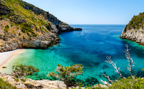 Dafina Bay with clear turquoise waters and rocky cliffs.