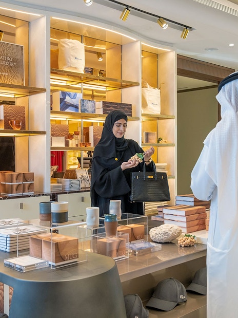 Tourists exploring luxury items at UMA Lounge gift shop during Inside Burj Al Arab Tour in Dubai.