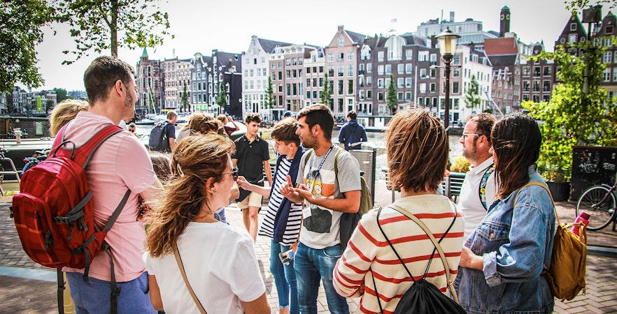 Tour guide explaining Amsterdam's Jordaan district to tourists near Anne Frank House.