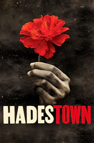 Hand holding a red flower with "Hadestown" text, Westend theater production.
