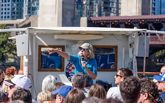 Tour guide speaking to passengers on a Chicago architecture cruise.