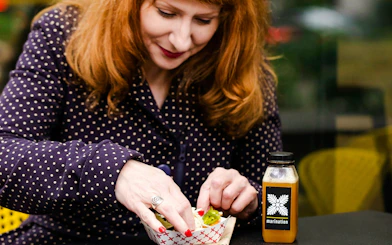 Person enjoying food with Marination sauce during Seattle Happy Hour Tour.