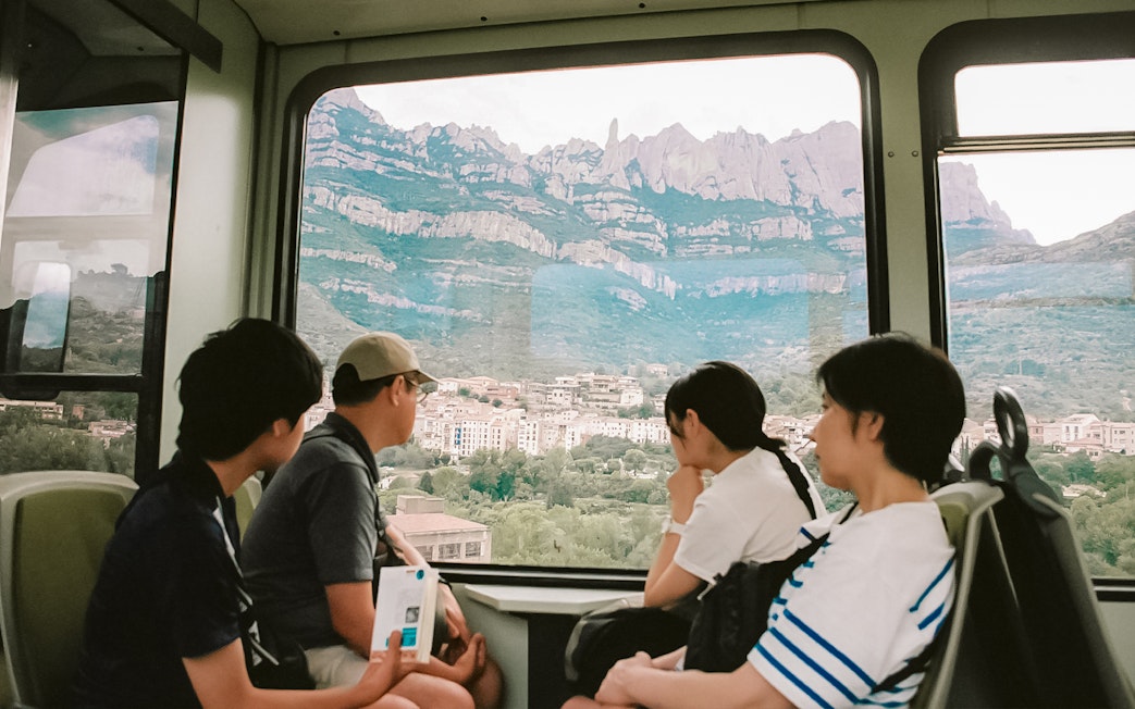 Tourists on train to Montserrat Monastery with mountain view from Barcelona.