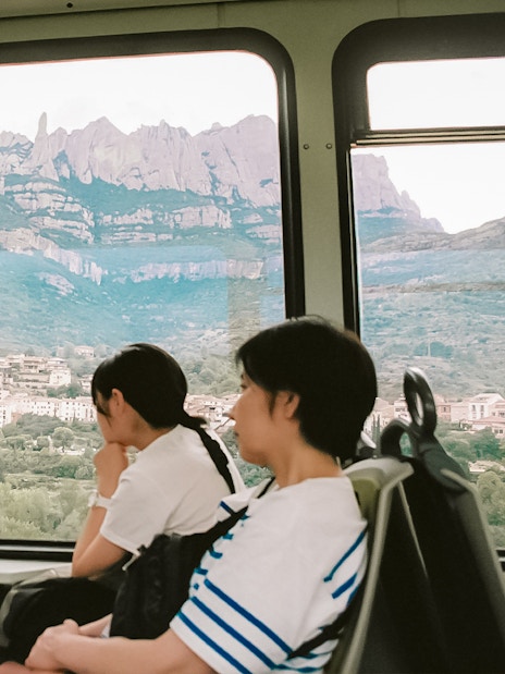 Tourists on train to Montserrat Monastery with mountain view from Barcelona.