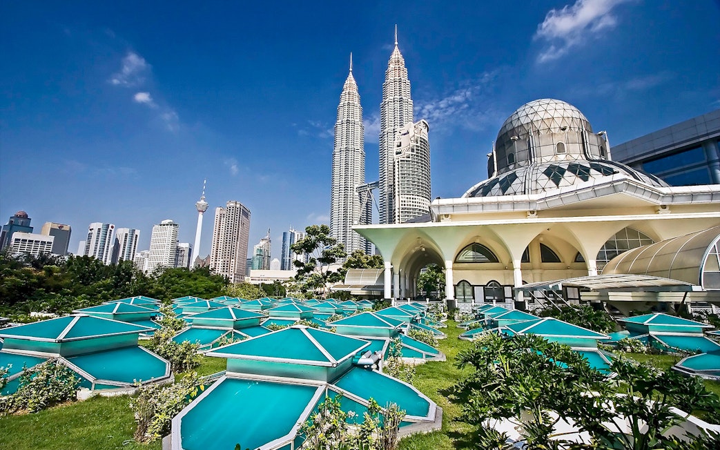 Petronas Twin Towers and Kuala Lumpur skyline with modern architecture in foreground.