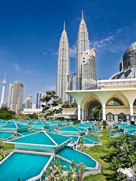 Petronas Twin Towers and Kuala Lumpur skyline with modern architecture in foreground.