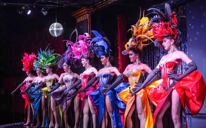 Performers in colorful costumes at Calypso Cabaret show, Bangkok.