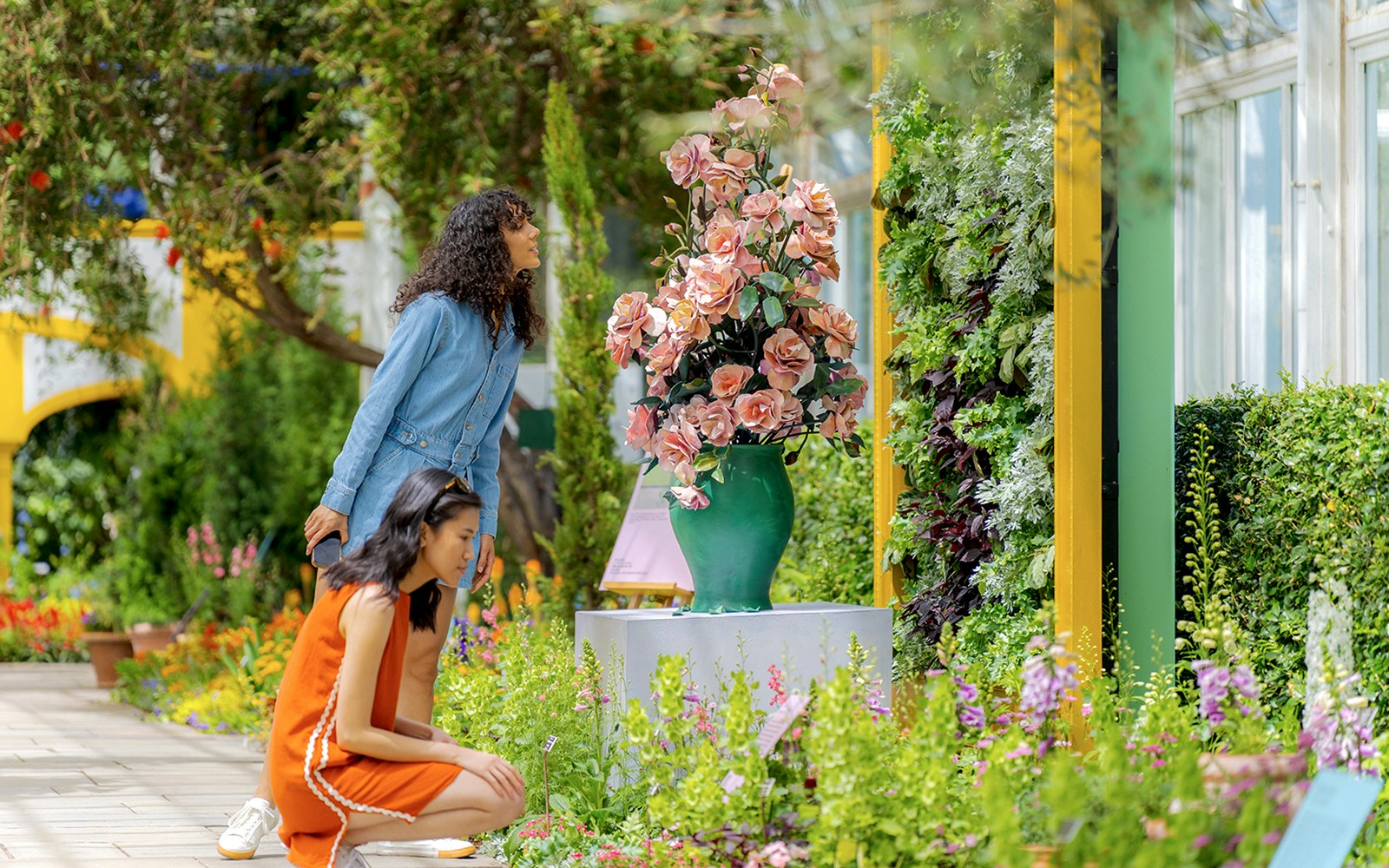 Visitors walking through the lush greenery of New York Botanical Garden.