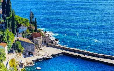Coastal view of a stone pier and buildings in Dubrovnik, Croatia, featured in Game of Thrones.