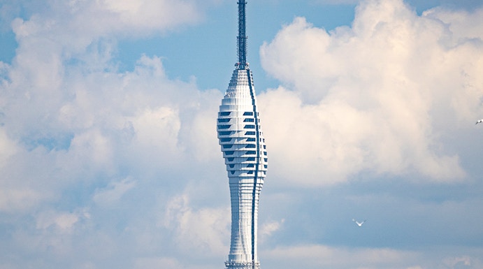 Camlica Tower in Istanbul rising above a green landscape under a cloudy sky.