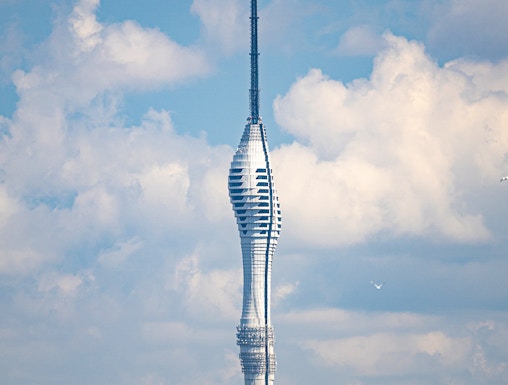 Camlica Tower in Istanbul rising above a green landscape under a cloudy sky.