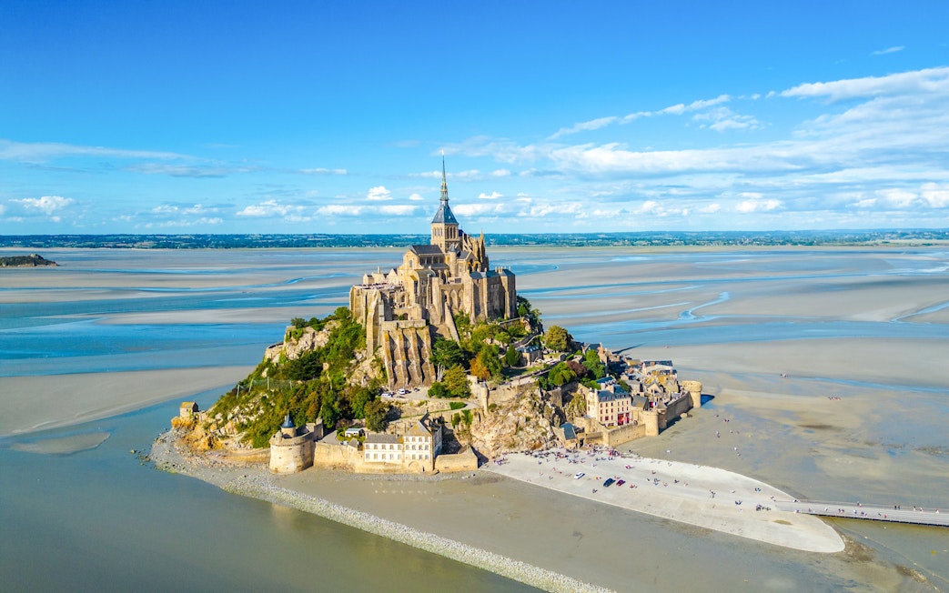Mont-Saint-Michel with Abbey surrounded by tidal waters in Normandy, France.