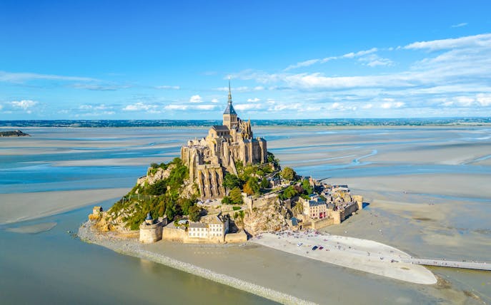 Mont-Saint-Michel with Abbey surrounded by tidal waters in Normandy, France.