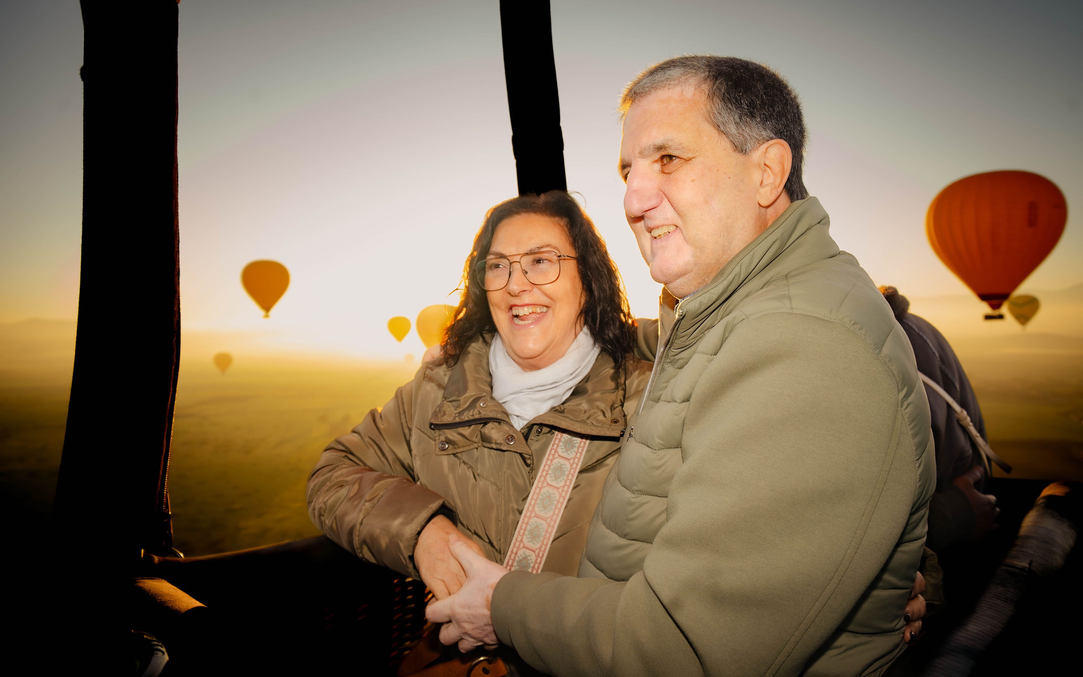 Couple enjoying a hot air balloon flight over Marrakech at sunrise.