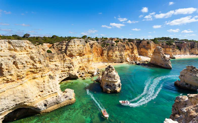 Boats touring the Benagil Caves along the Albufeira coastline, Portugal.