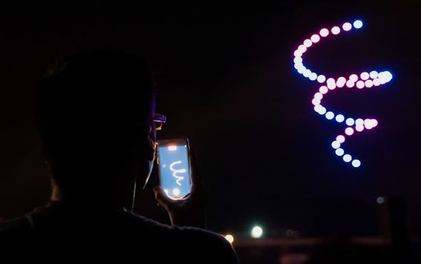 Drone light display at Camp Nou during the Luminous Show, viewed by a person with a phone.