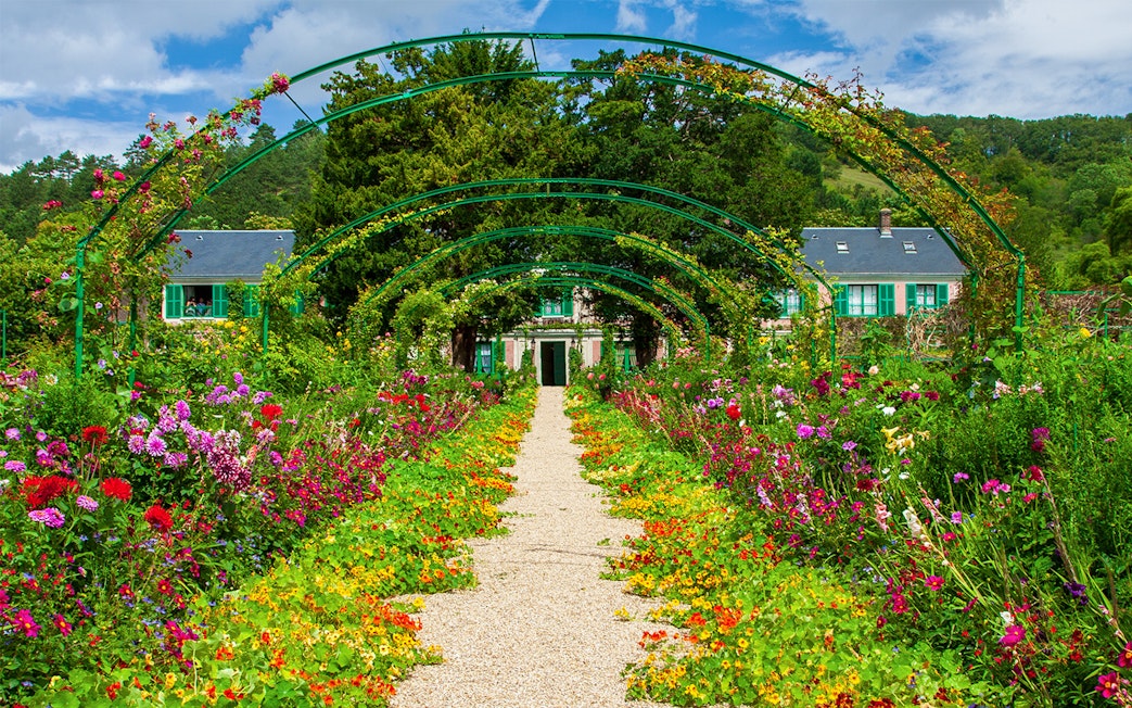 Pathway through vibrant gardens leading to Monet's House in Giverny, France.