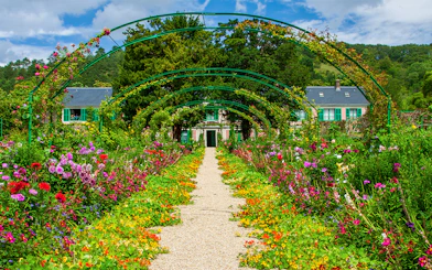 Pathway through vibrant gardens leading to Monet's House in Giverny, France.