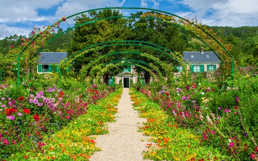 Pathway through vibrant gardens leading to Monet's House in Giverny, France.