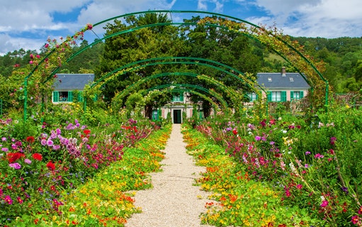 Pathway through vibrant gardens leading to Monet's House in Giverny, France.