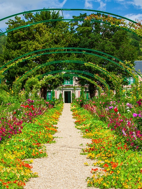 Pathway through vibrant gardens leading to Monet's House in Giverny, France.