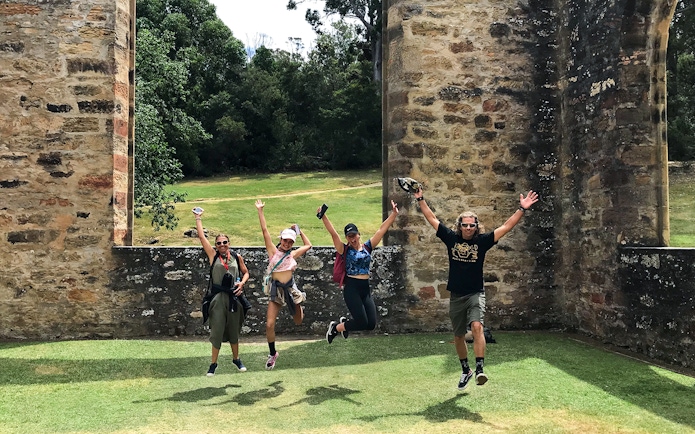 Visitors jumping in front of historic ruins at Port Arthur, Tasman Peninsula.