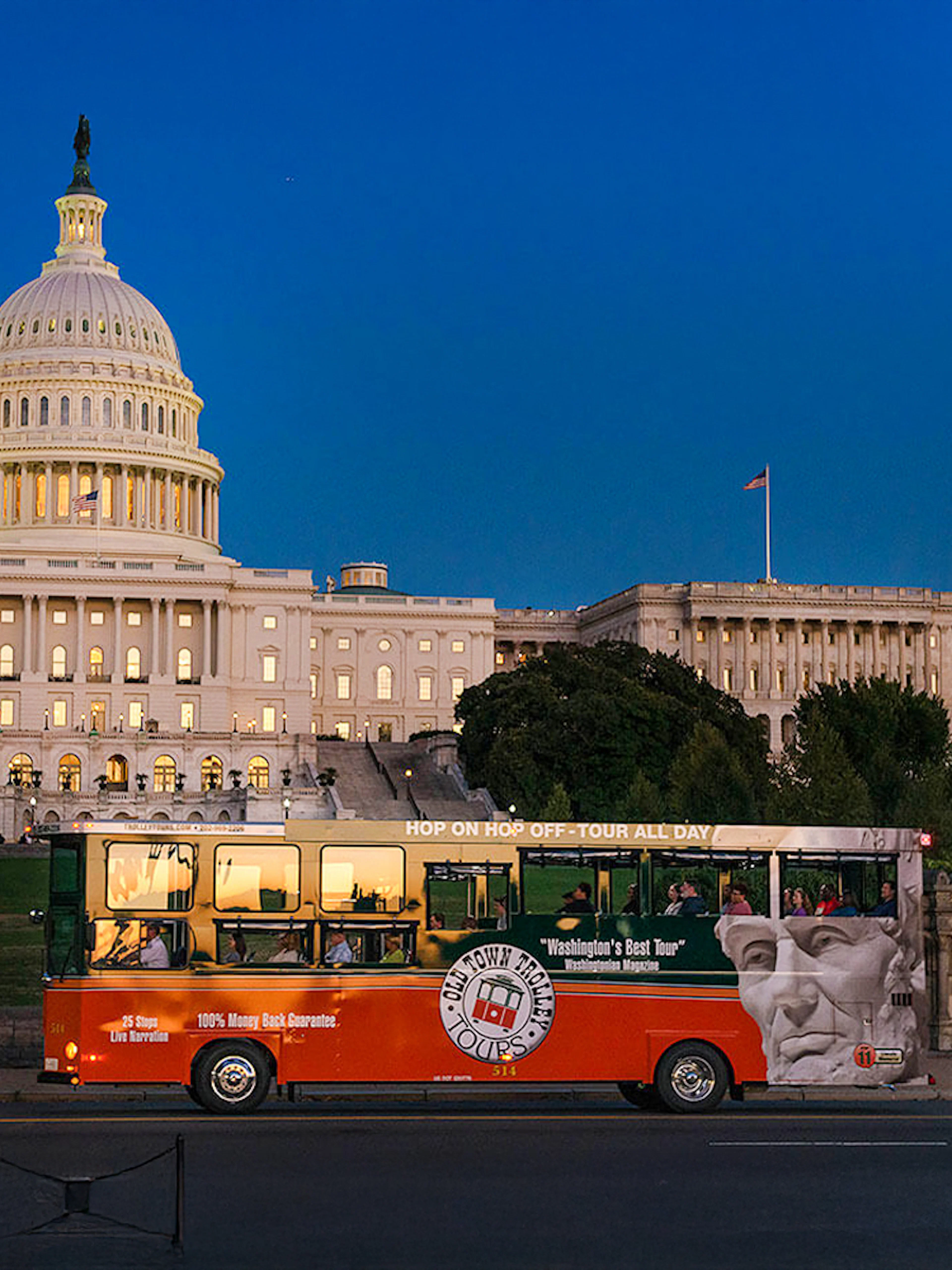 Tour bus passing by illuminated Capitol Hill at night, Washington, DC.
