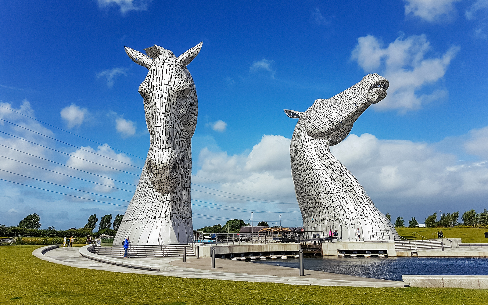 Kelpies sculptures in Falkirk, Scotland, under a blue sky.